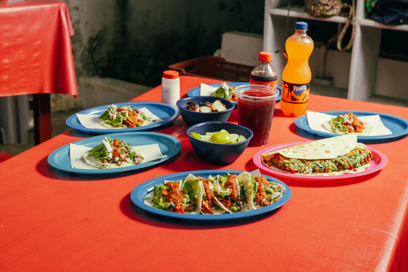Mesa llena de tacos, salsas y bebidas